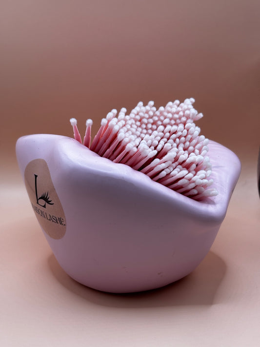 Maison Lashé pink microfibre brushes in a curved white cup with bristles for precise lash application against a blush background
