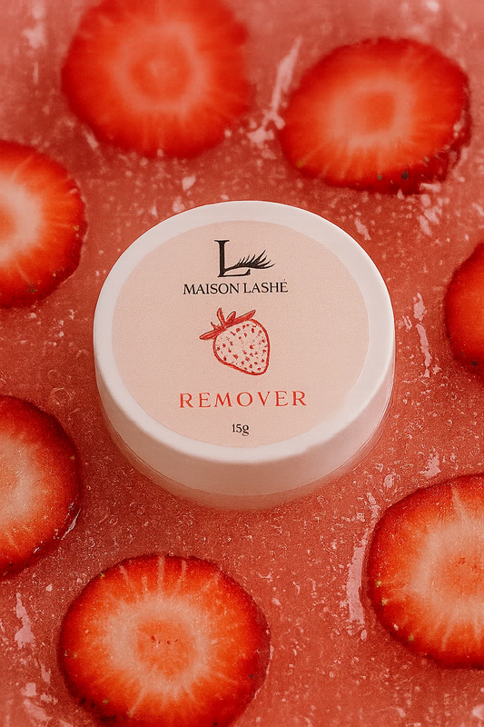 Maison Lashé strawberry-scented cream remover for eyelash extensions; pink pot surrounded by fresh strawberries, used for gentle, safe lash removal